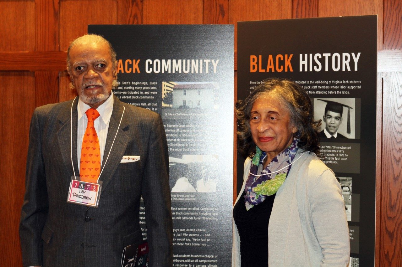 Irvinig Peddrew and Marsha Woodson stand in front of signage that reads Black Community and Black History. 