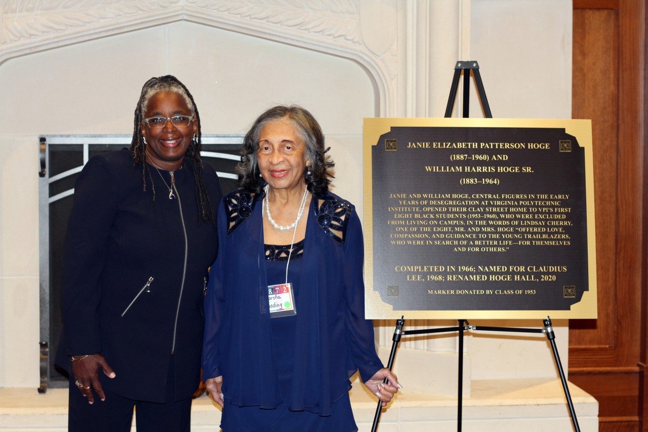 Dr. Menah Pratt and granddaughter of the Hoge family stand next to a display recognizing the Hoge family for welcoming Virginia Tech's first Black male students to reside in their home.